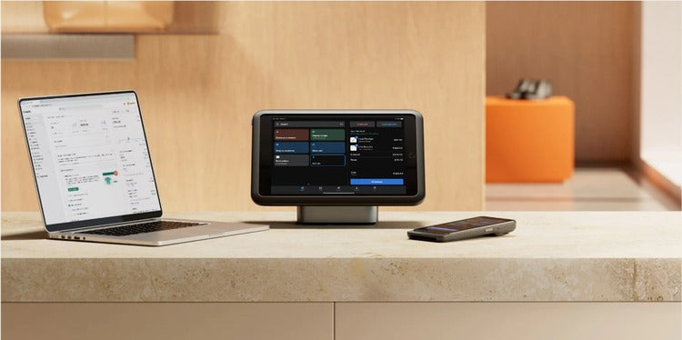 Shopify POS terminal and laptop set up on a retail counter